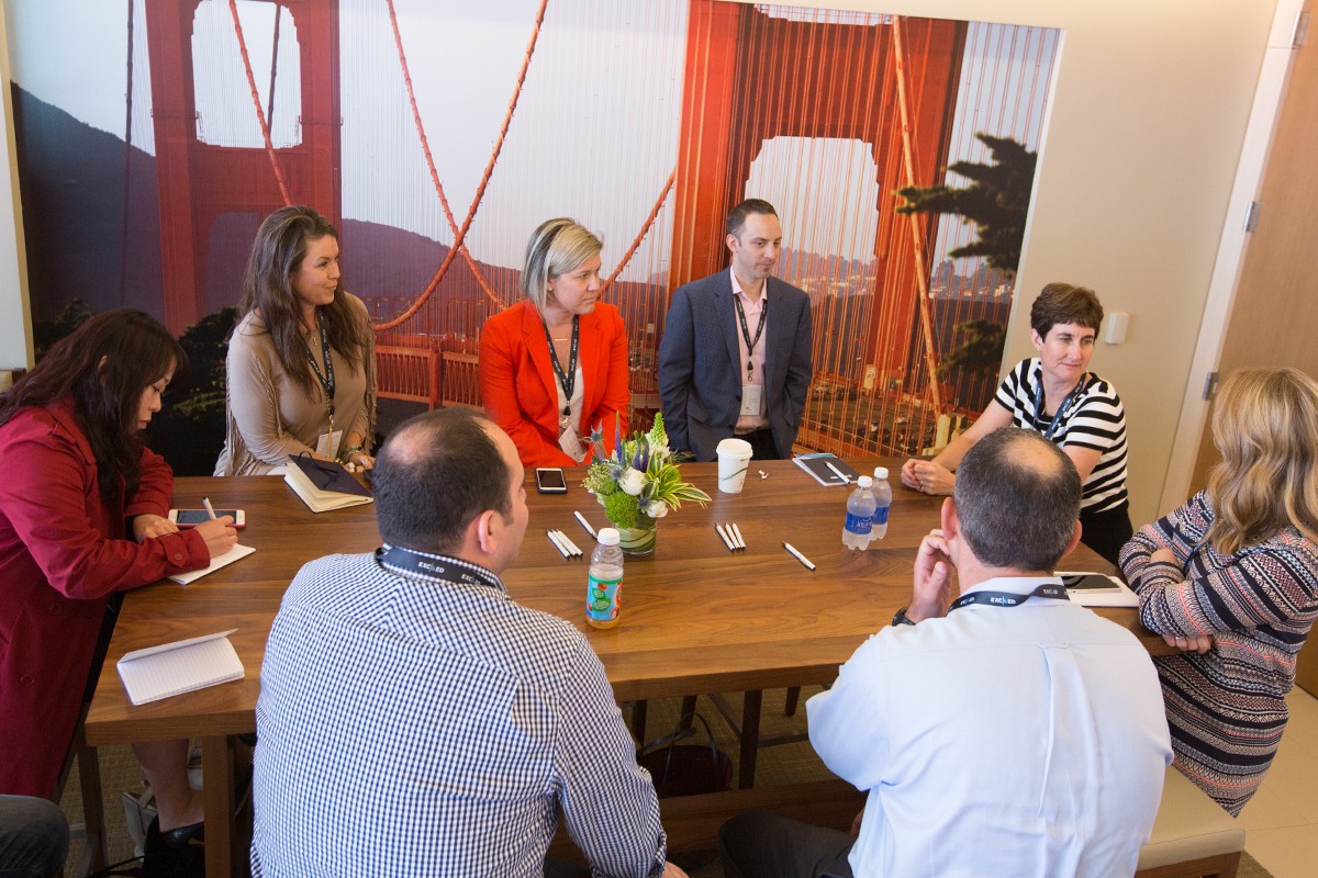 Photograph of a group of revenue leaders at a sales planning meeting talking around a conference table