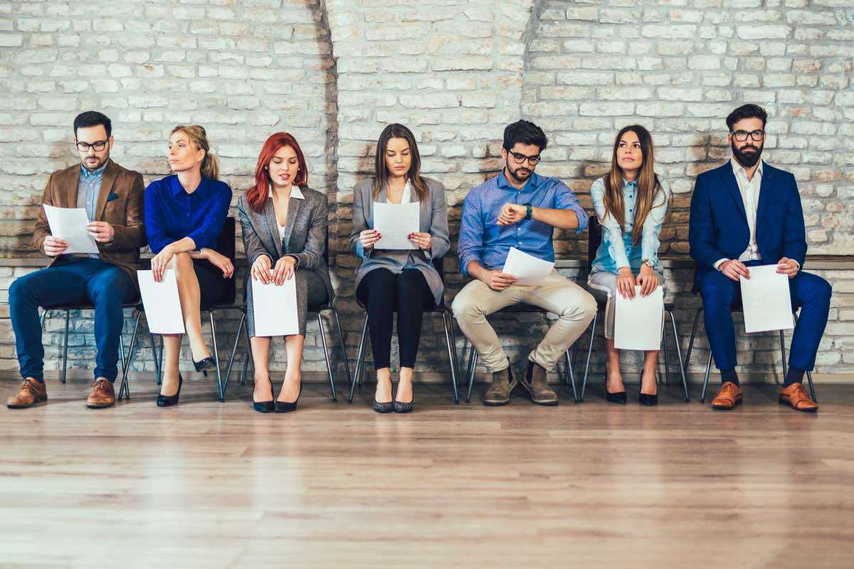 Job seekers sitting in chairs waiting for interviews