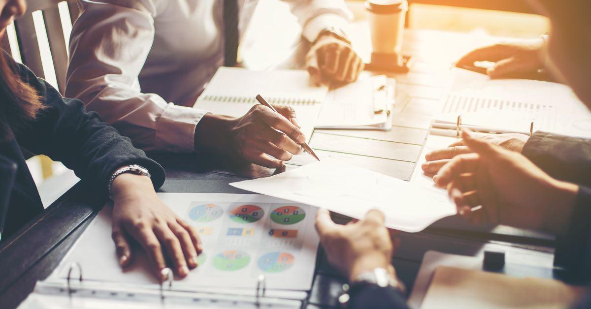 sales-linearity Photograph of sales leaders discussing forecast reports at a conference table