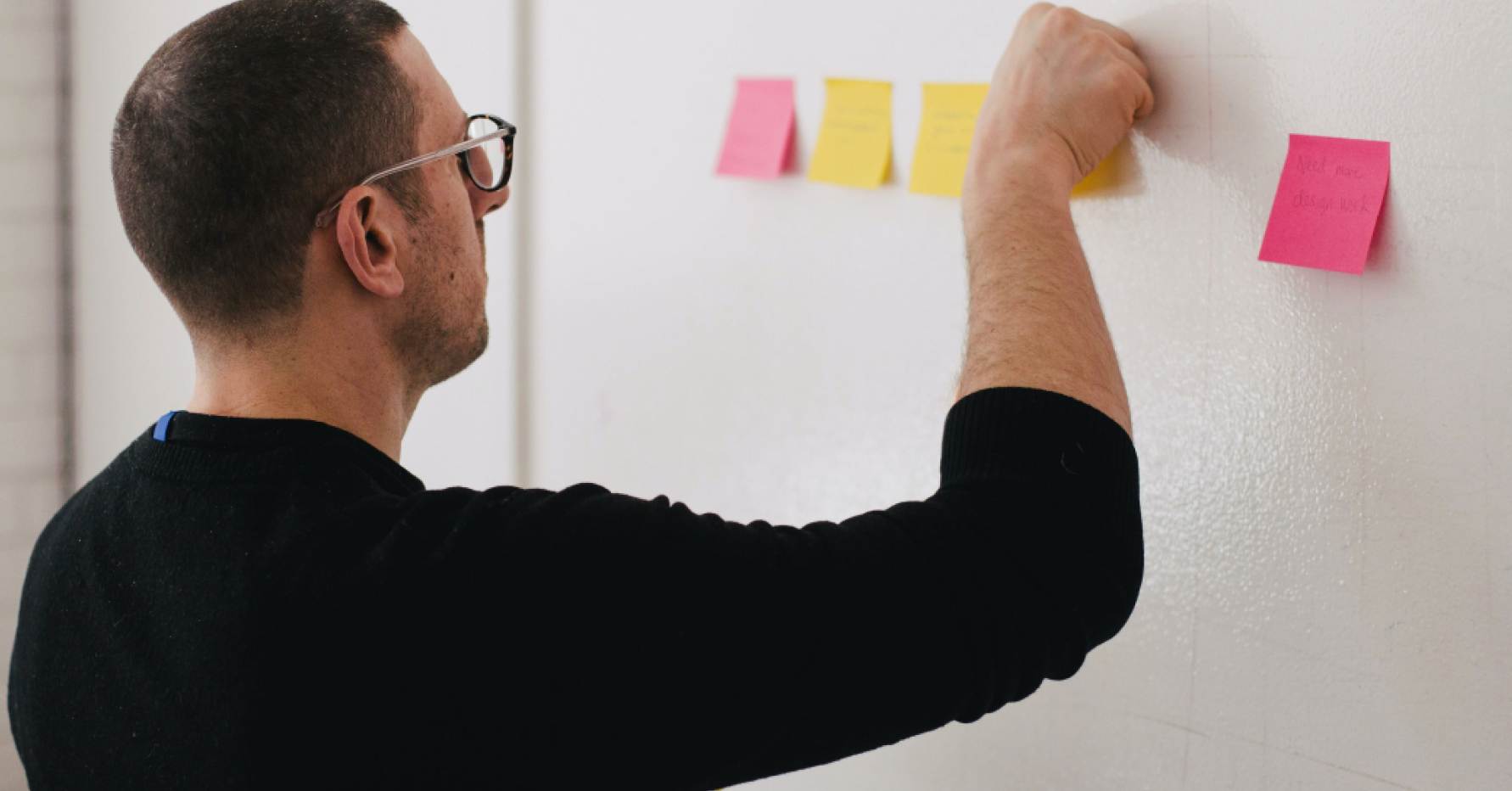 Man placing sticky notes on a whiteboard
