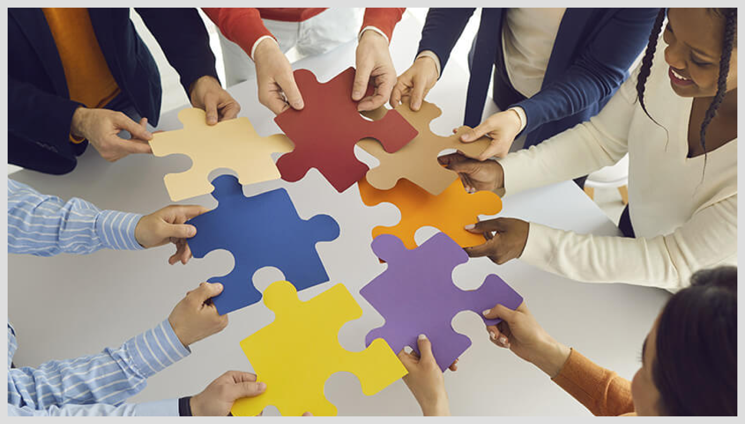 Group of people putting together large puzzle pieces