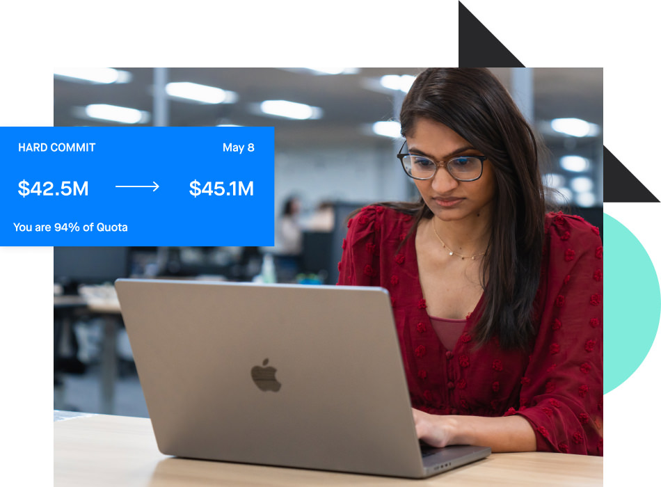 Photograph of a revenue leader looking at a Clari quota report on a laptop
