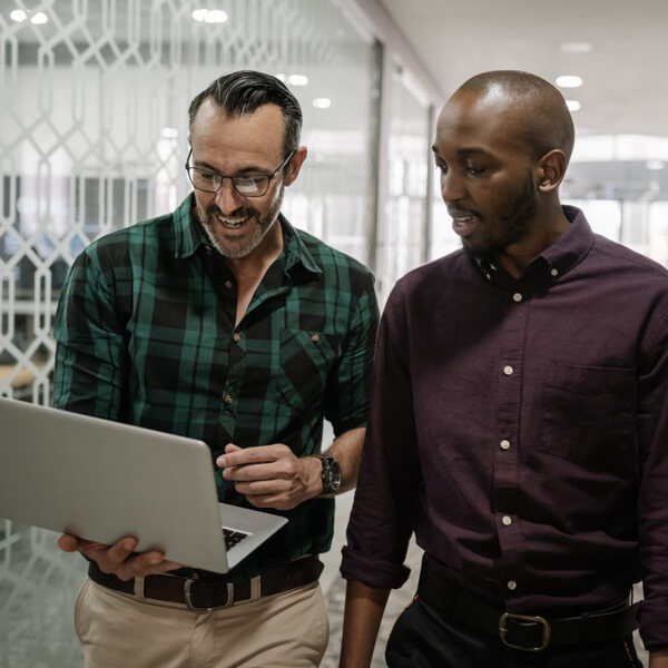 Two revenue leaders looking at a laptop and discussing the pricing of the Clari Revenue Platform