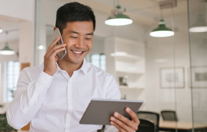 Photograph of a financial services relationship manager talking on a phone and looking at a tablet