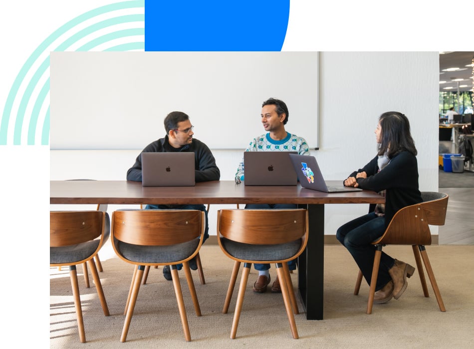 Photograph of three revenue professionals sitting at a conference table